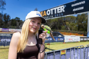 Smiling young woman in a white cap in front of Sea Otter banners