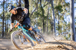 Mountain biker leaning into a dusty berm in the forest