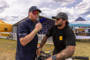 Two men talking, one holding a microphone, at the Sea Otter expo