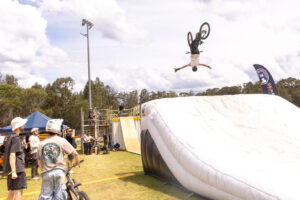 Rider upside down in a backflip above a large white landing bag