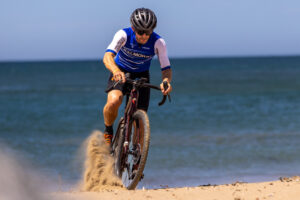 Rider splashing through shallow water at the edge of the sea
