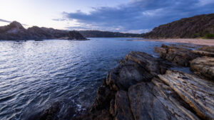 Rocky shoreline and calm bay water looking north near Batemans Bay